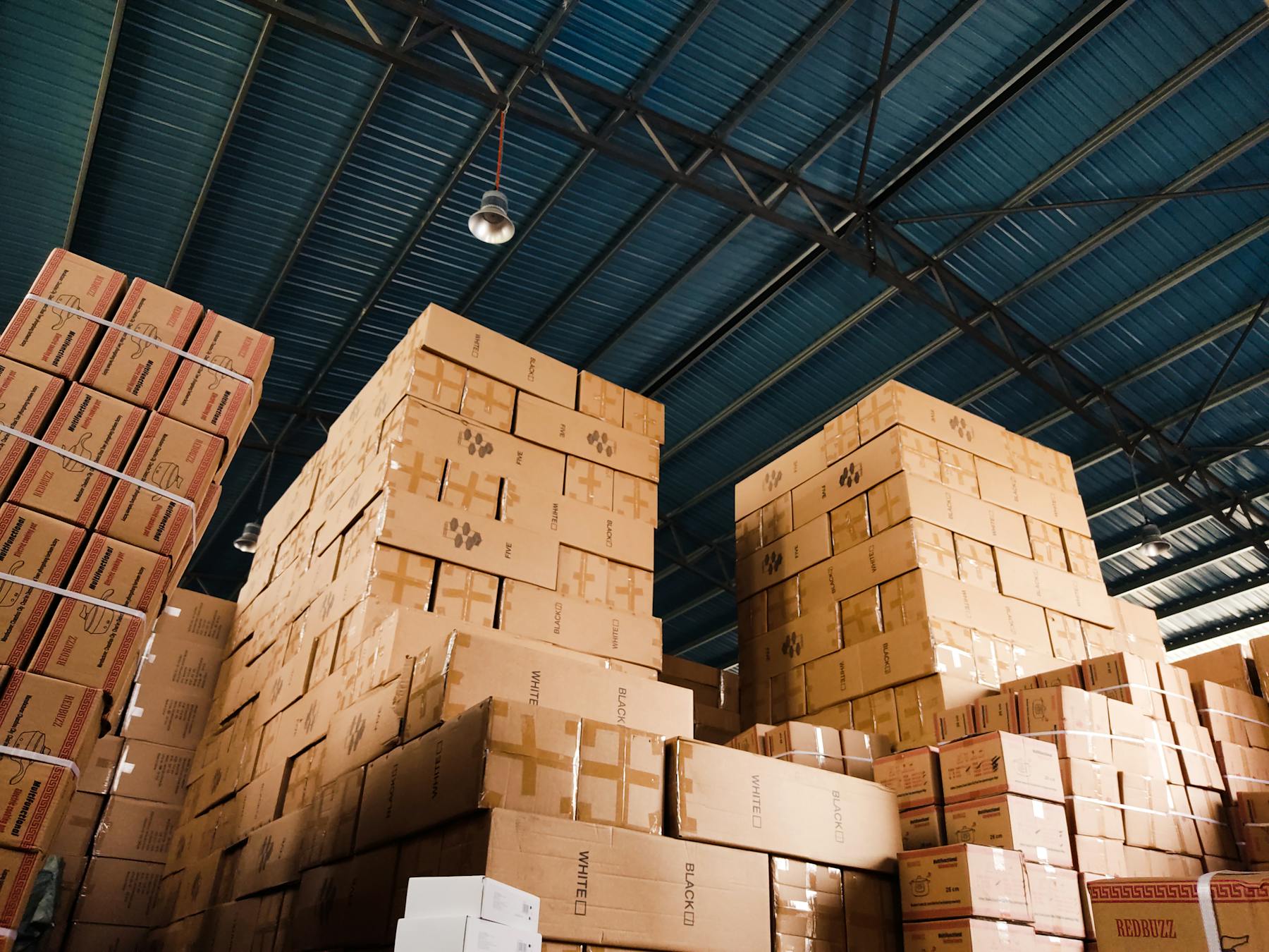 Pallets of boxed goods stacked inside a warehouse.